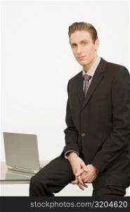 Portrait of a businessman sitting on a desk