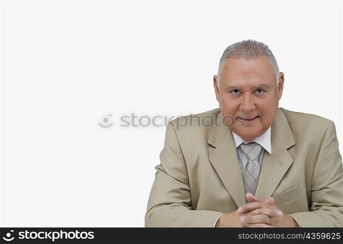 Portrait of a businessman sitting with his hands clasped