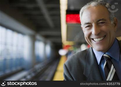 Portrait of a businessman smiling at a subway station