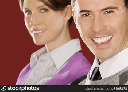 Portrait of a businessman smiling with a businesswoman behind him
