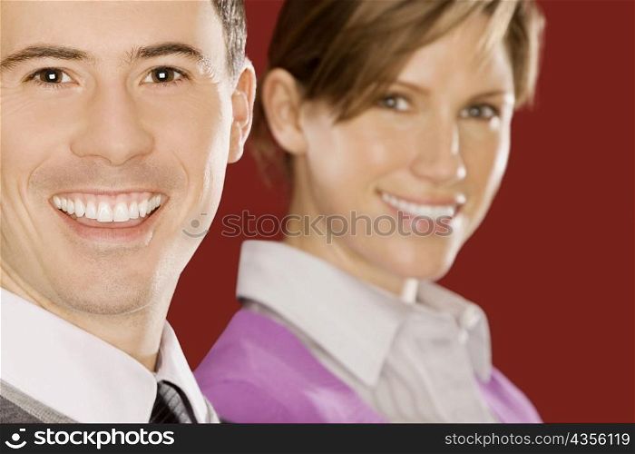 Portrait of a businessman smiling with a businesswoman behind him