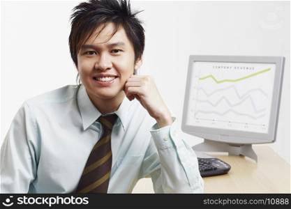 Portrait of a businessman smiling with a progress report in the background