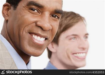 Portrait of a businessman smiling with another businessman smiling beside him