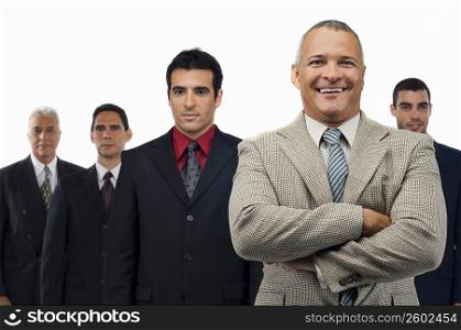 Portrait of a businessman smiling with four businessmen standing behind him