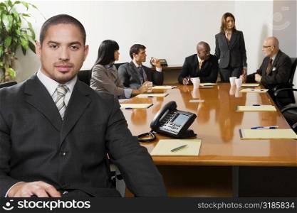 Portrait of a businessman smiling with other business executives in a board room