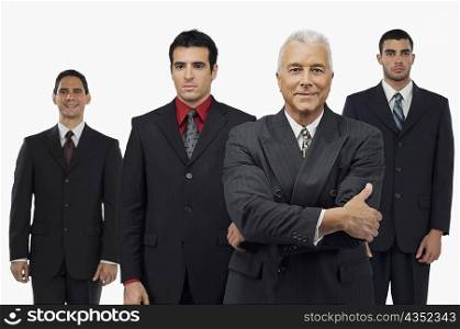 Portrait of a businessman smiling with three businessmen standing behind him