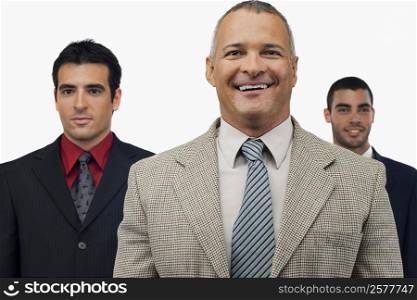 Portrait of a businessman smiling with two businessmen standing behind him