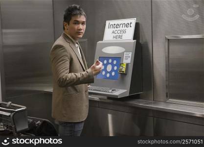 Portrait of a businessman standing at a public internet point at an airport