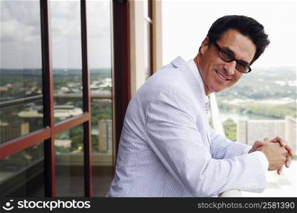Portrait of a businessman standing in a balcony and smiling