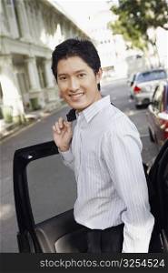 Portrait of a businessman standing near a car and smiling