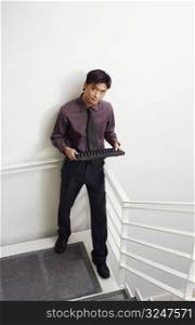 Portrait of a businessman standing on a staircase and holding an abacus