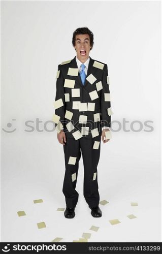 Portrait of a businessman standing with adhesive notes on his body