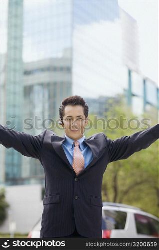 Portrait of a businessman standing with his arms outstretched and smiling