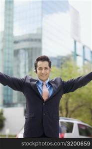 Portrait of a businessman standing with his arms outstretched and smiling