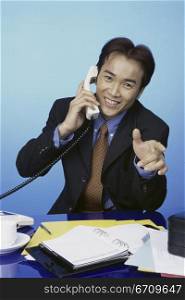 Portrait of a businessman talking on a landline telephone