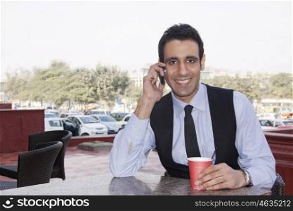 Portrait of a businessman talking on a mobile phone , INDIA , DELHI
