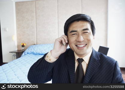 Portrait of a businessman talking on a mobile phone smiling