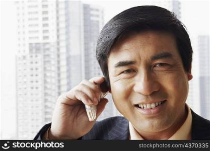 Portrait of a businessman talking on a mobile phone smiling