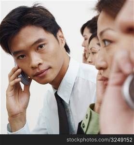 Portrait of a businessman talking on a mobile phone with his colleagues
