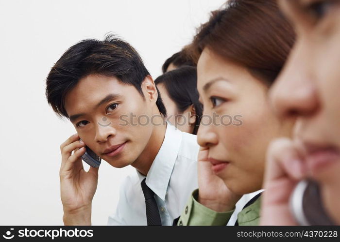 Portrait of a businessman talking on a mobile phone with his colleagues