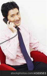 Portrait of a businessman talking on the telephone and smiling