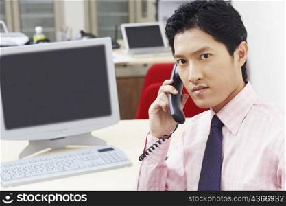 Portrait of a businessman talking on the telephone in an office