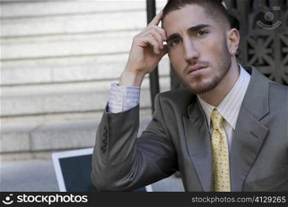 Portrait of a businessman thinking with his head in his hand