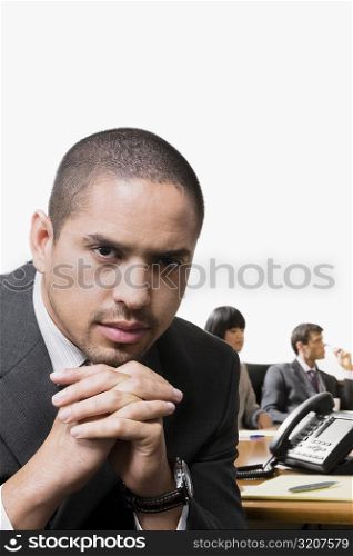 Portrait of a businessman thinking with other business executives in a board room