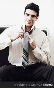 Portrait of a businessman tying his tie