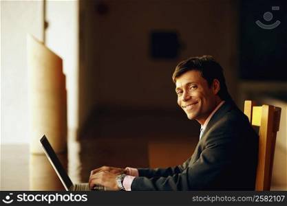 Portrait of a businessman typing on a laptop