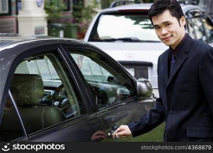 Portrait of a businessman unlocking a car door