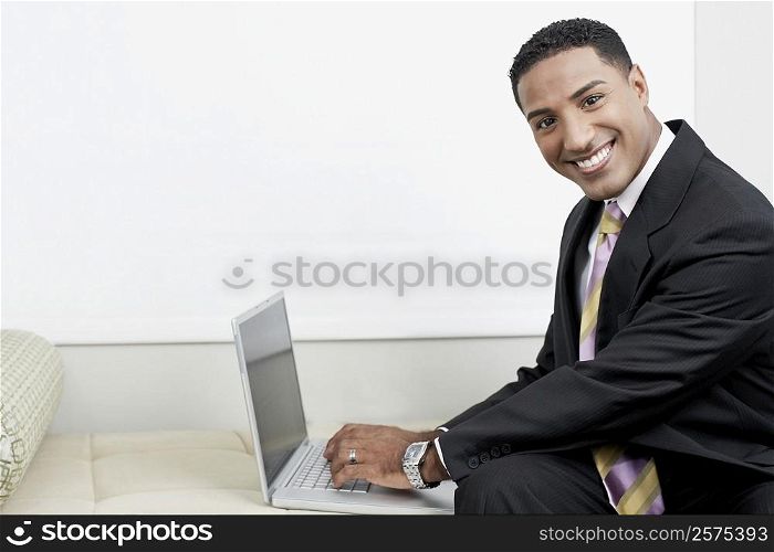 Portrait of a businessman using a laptop and smiling