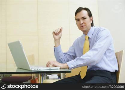 Portrait of a businessman using a laptop in an office