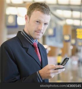 Portrait of a businessman using a mobile phone at an airport lounge