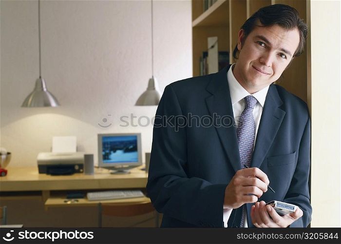 Portrait of a businessman using a personal data assistant