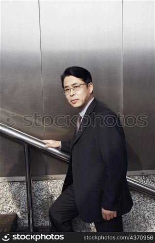 Portrait of a businessman walking up a staircase