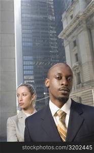 Portrait of a businessman with a businesswoman standing behind him