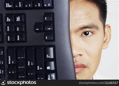 Portrait of a businessman with a computer keyboard in front of his face
