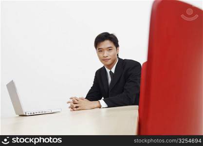 Portrait of a businessman with a laptop in a board room