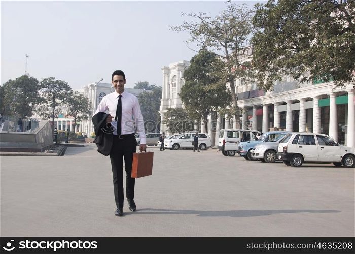 Portrait of a businessman with a suitcase walking , INDIA , DELHI