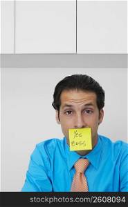Portrait of a businessman with an adhesive note on his mouth