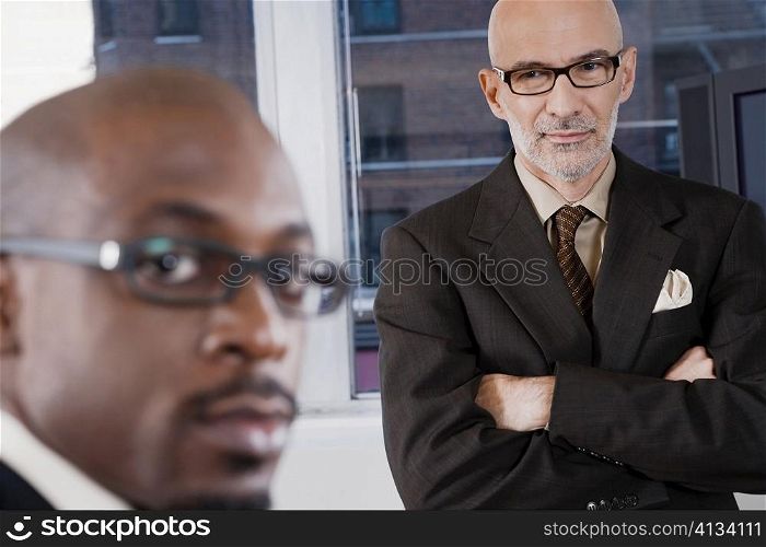 Portrait of a businessman with another businessman standing behind him