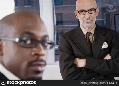 Portrait of a businessman with another businessman standing behind him