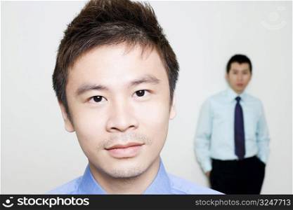 Portrait of a businessman with another standing behind him