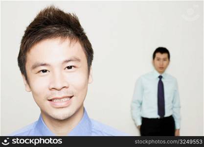 Portrait of a businessman with another standing behind him