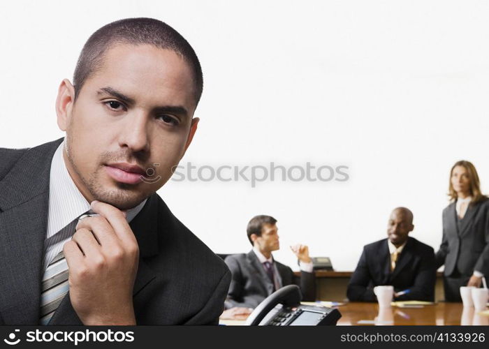 Portrait of a businessman with his colleagues discussing in the background