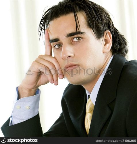 Portrait of a businessman with his finger on his head