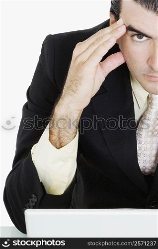 Portrait of a businessman with his head in his hands thinking