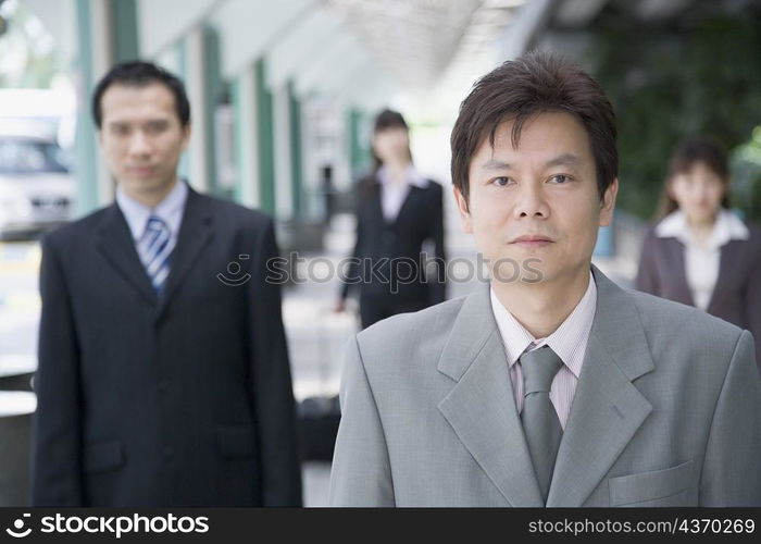 Portrait of a businessman with three business executives in the background