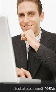 Portrait of a businessman working on a laptop and smiling